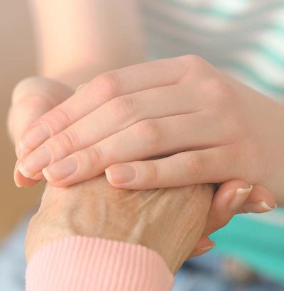 senior holding hands with a caregiver