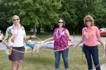 Three employees trying hula hoops at Wesley's employee picnic.