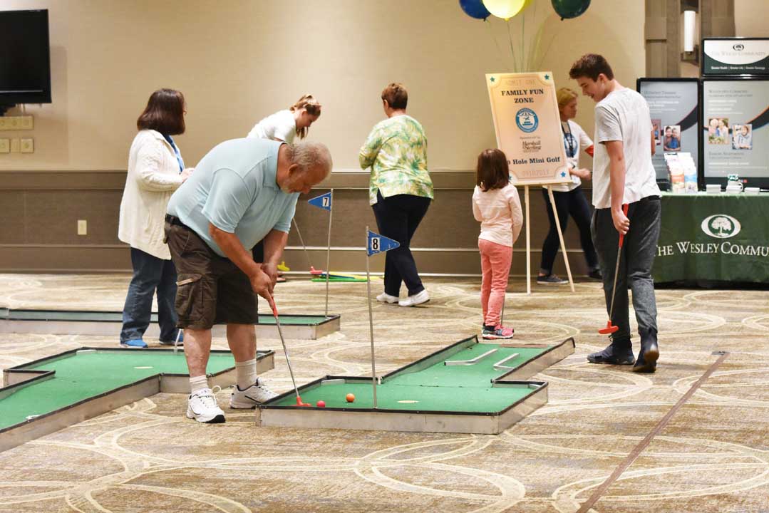 group of people playing miniature golf at a community event