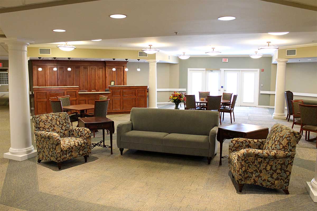 lobby with couches, tables, chairs and receptionist area at the Woodlawn Commons assisted/enriched senior living community