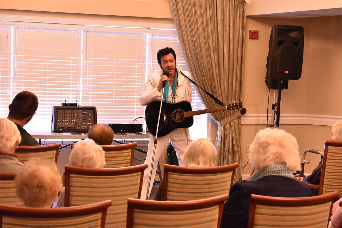 Elvis impersonator performing in front of group