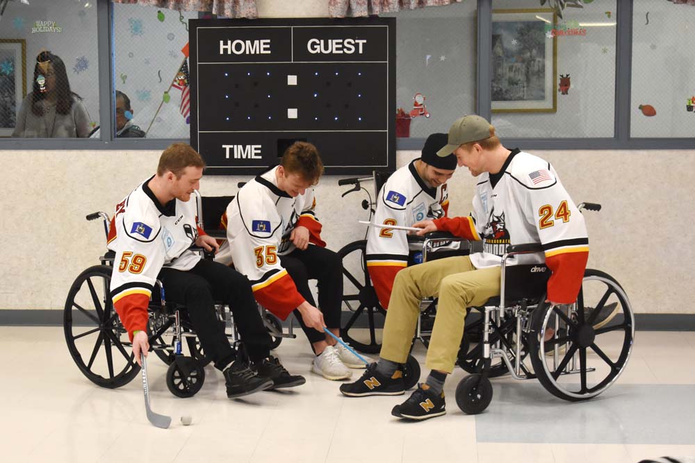 hockey players in wheel chairs playing floor hockey