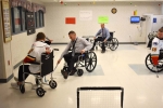 staff playing floor hockey in wheelchairs