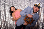 couple posing for photo with ship wheel