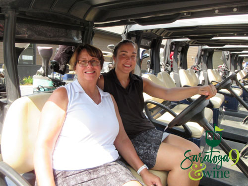 women smiling on golf cart
