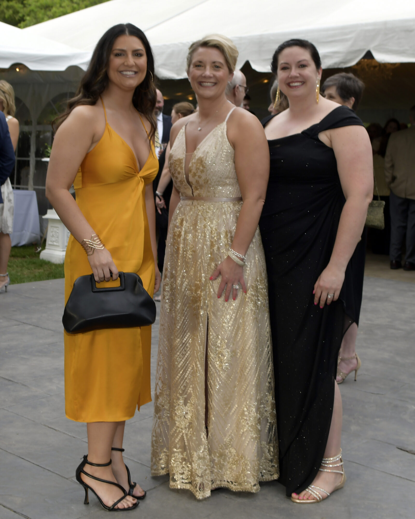 3 women iin dresses pose for photo