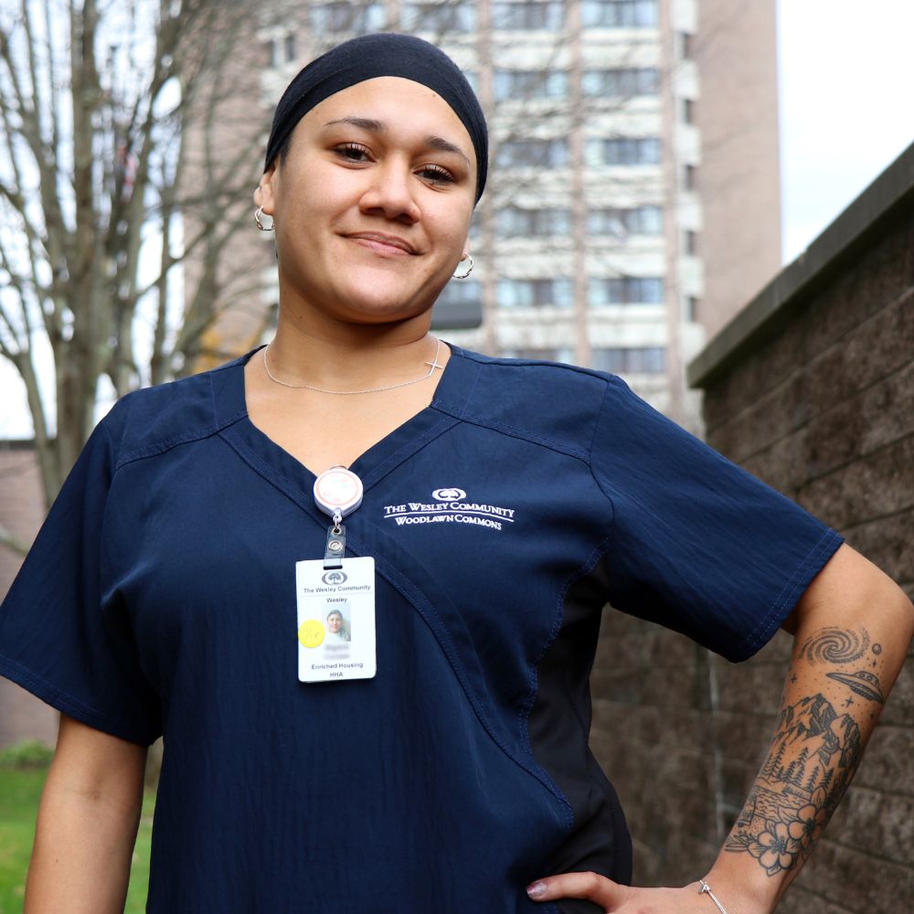 a nurse outside of The Wesley Community smiling.